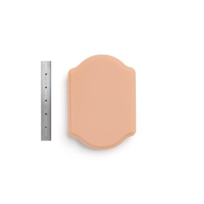 A Pound of Flesh Micro Series Tattooable Synthetic Small Plaque in Fitzpatrick Tone 2 shown with ruler for scale