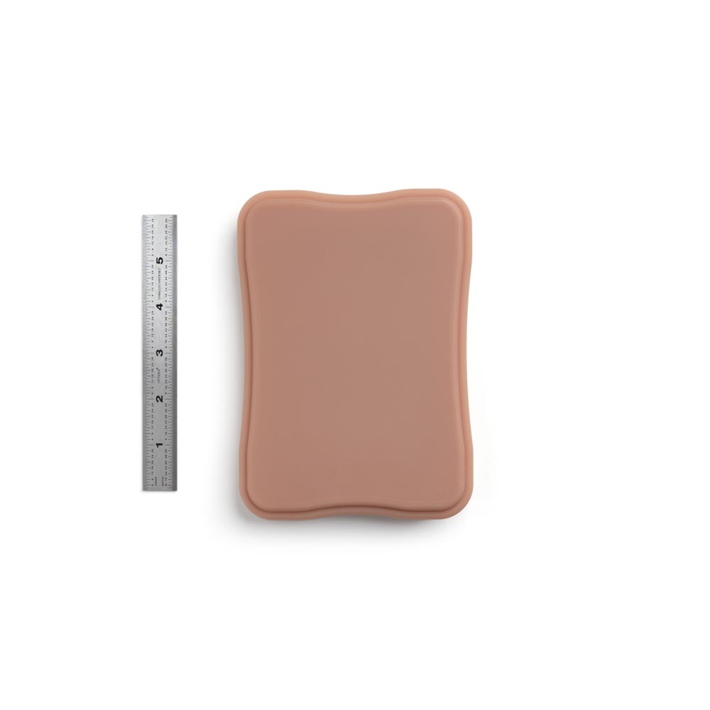 A Pound of Flesh Micro Series Tattooable Synthetic Small Square Plaque in Fitzpatrick Tone 4 shown with six inch ruler for scale